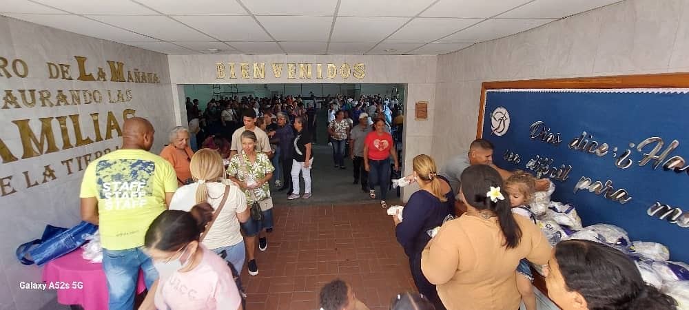 Familias recibiendo panes durante la jornada en la Iglesia Luz del Mundo